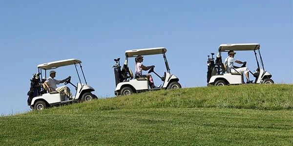 three golf carts riding one behind the other